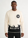 Model wearing iLLionaire Society Cream Crewneck Sweater with Black NYC Skyline Graphic, NYC streetwear, Dumbo Brooklyn